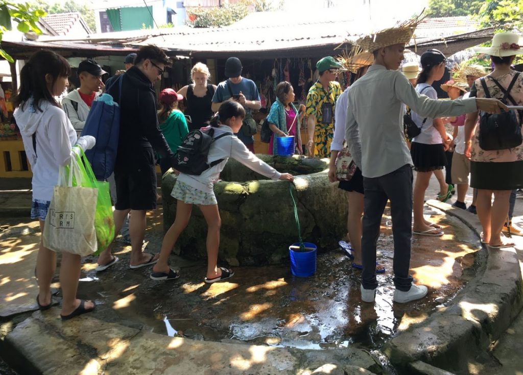 Khách du lịch tham quan và uống nước mát lạnh tại Giếng cổ Cù Lao Chàm